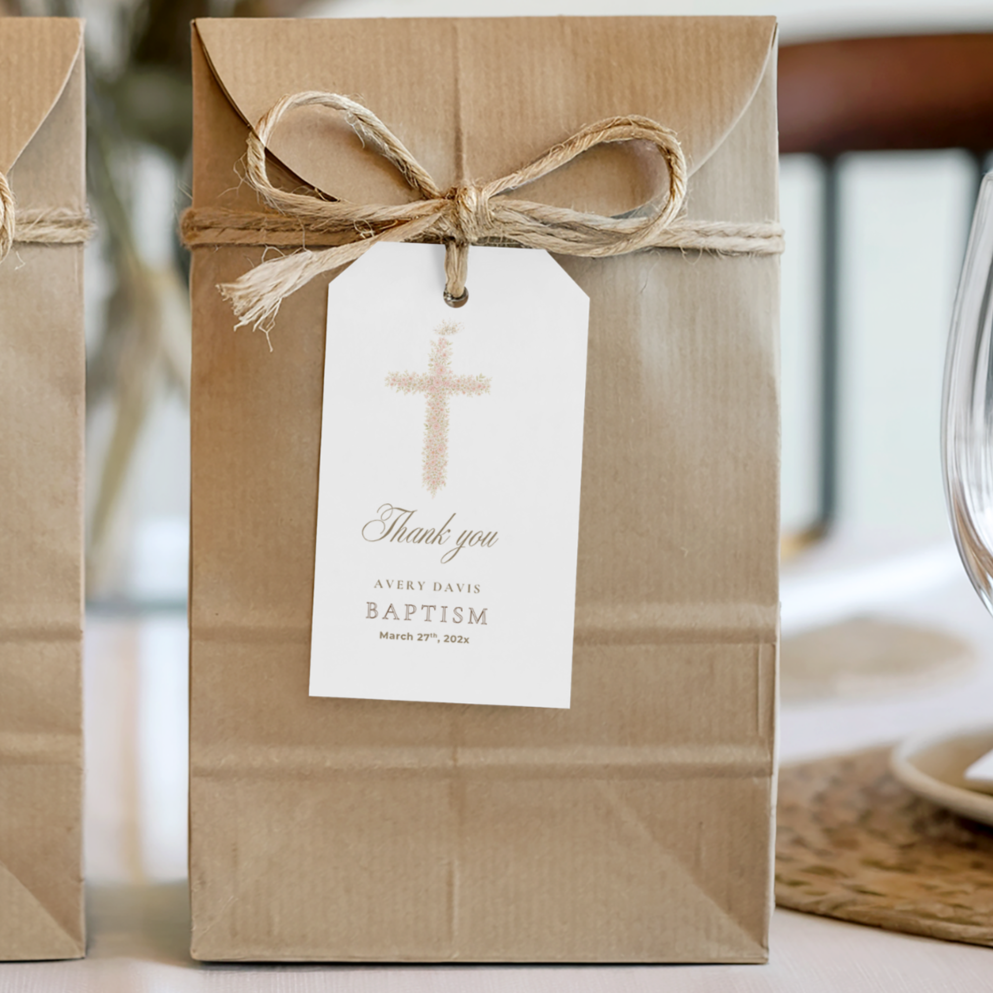 Soft pink floral baptism favor tag with elegant blush floral cross attached to kraft gift packaging