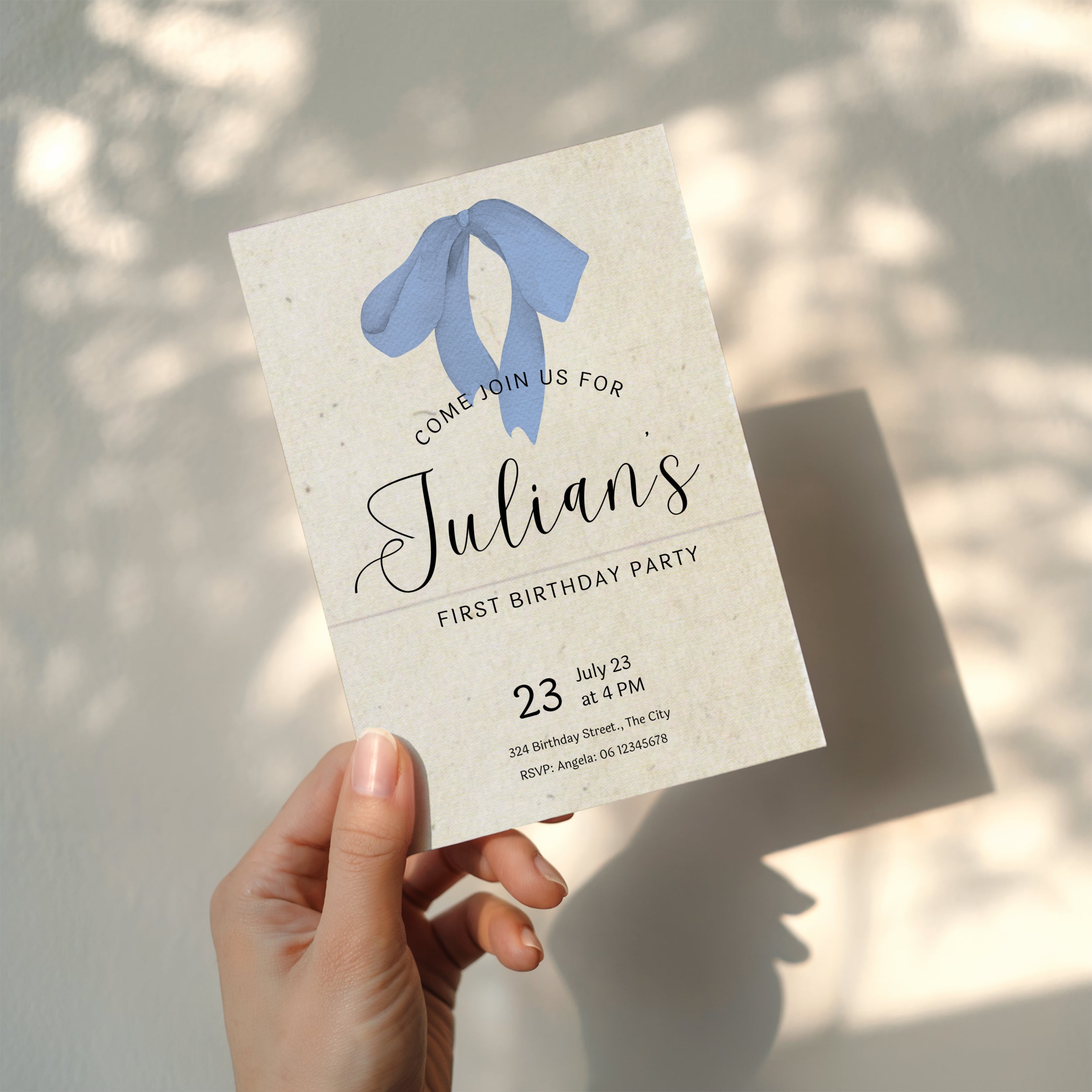 Minimalist first birthday invitation with blue bow illustration and soft neutral background