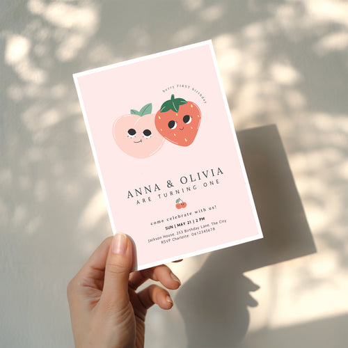 Berry first birthday twin invitation with strawberry and peach illustration and soft pink background
