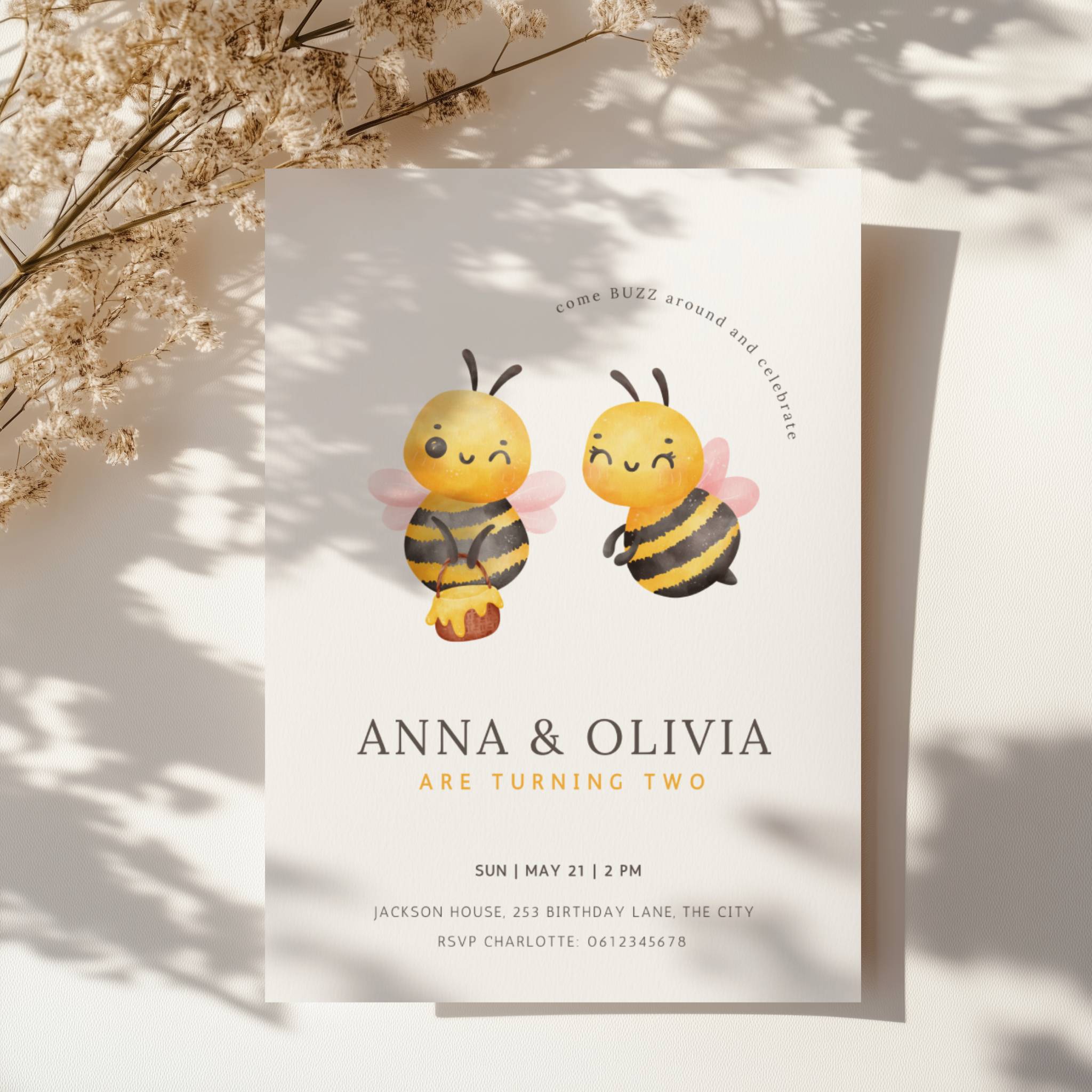 Twin birthday invitation with cute bee illustration and buzz around theme in soft yellow tones