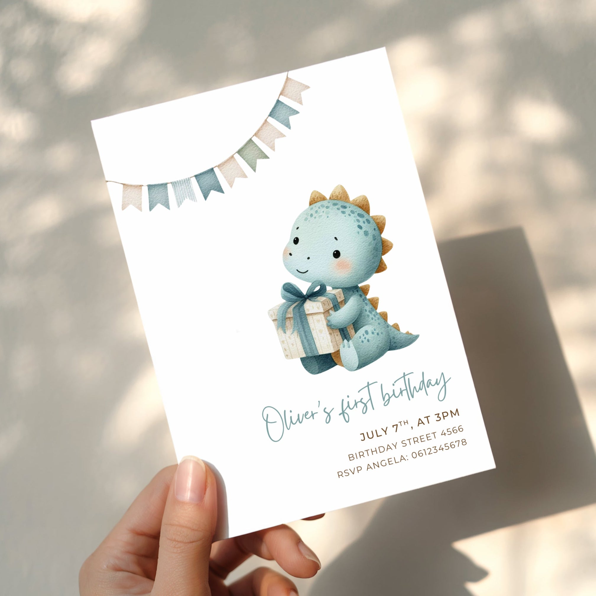 Dinosaur first birthday invitation with cute baby dinosaur holding a gift in soft pastel colors
