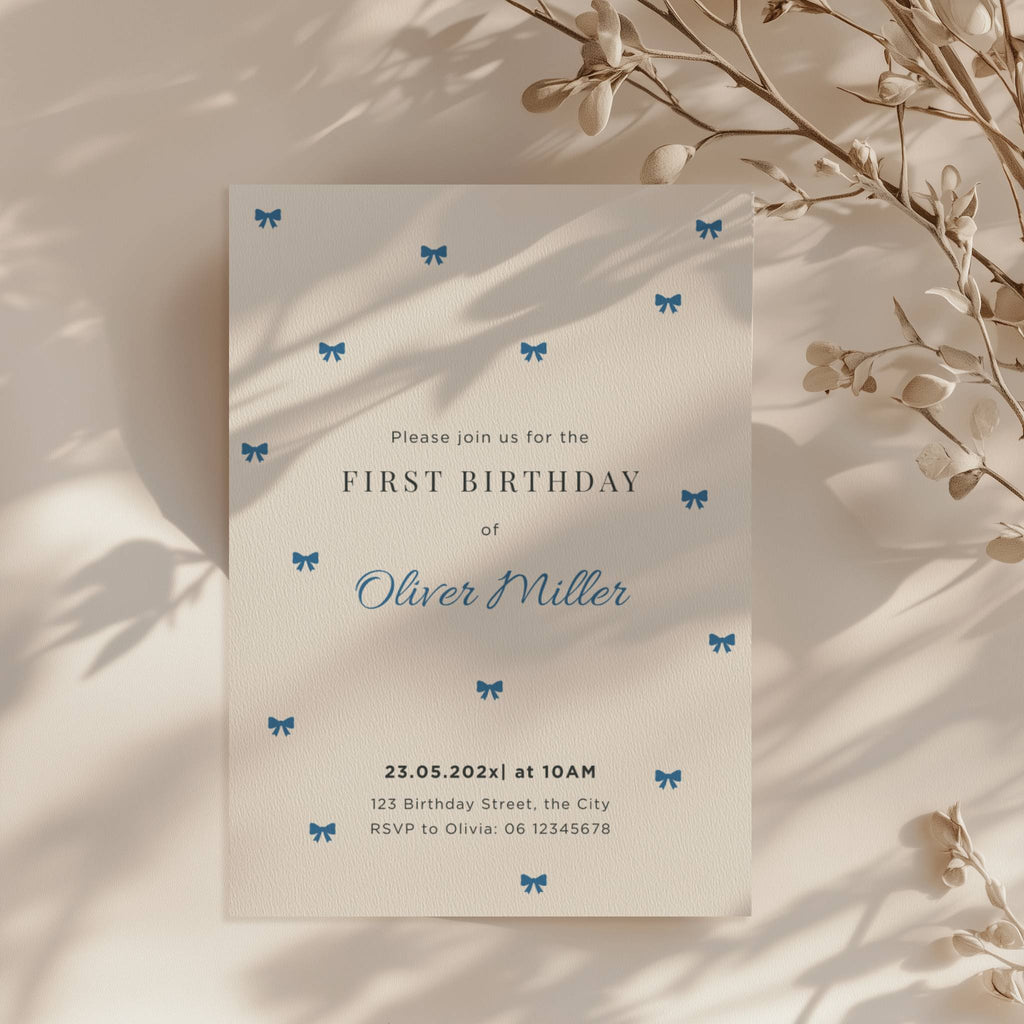 Minimal first birthday invitation with small blue bows and clean elegant design for a baby boy celebration