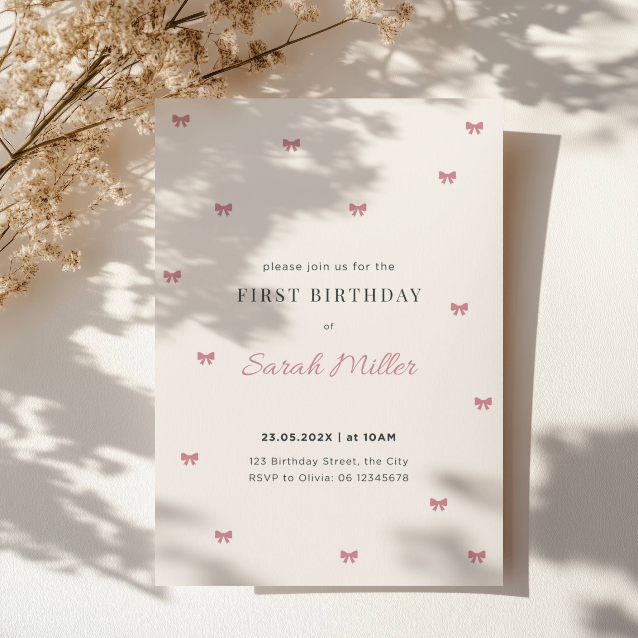 Minimal first birthday invitation with small pink bows and elegant clean design for a baby girl celebration