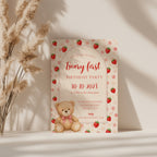 Editable Berry & Beary First birthday invitation with a teddy bear, strawberries, pink flowers, and an elegant arched design for a girl's first birthday party.