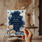 Classic Beary First birthday invitation featuring a teddy bear, blue balloons, birthday cake, vintage toy race car, and watercolor stars for a baby boy's first birthday.