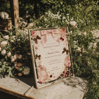Coquette birthday party invitation featuring pink satin bows, pearls, perfume bottles, cherries, roses, and leopard print accents in an elegant blush aesthetic.