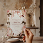 Coquette birthday party invitation featuring pink satin bows, pearls, perfume bottles, cherries, roses, and leopard print accents in an elegant blush aesthetic.