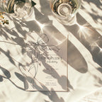 Minimalist black bow first birthday invitation with a hand-drawn ribbon, elegant black typography, and a clean white monochrome layout.