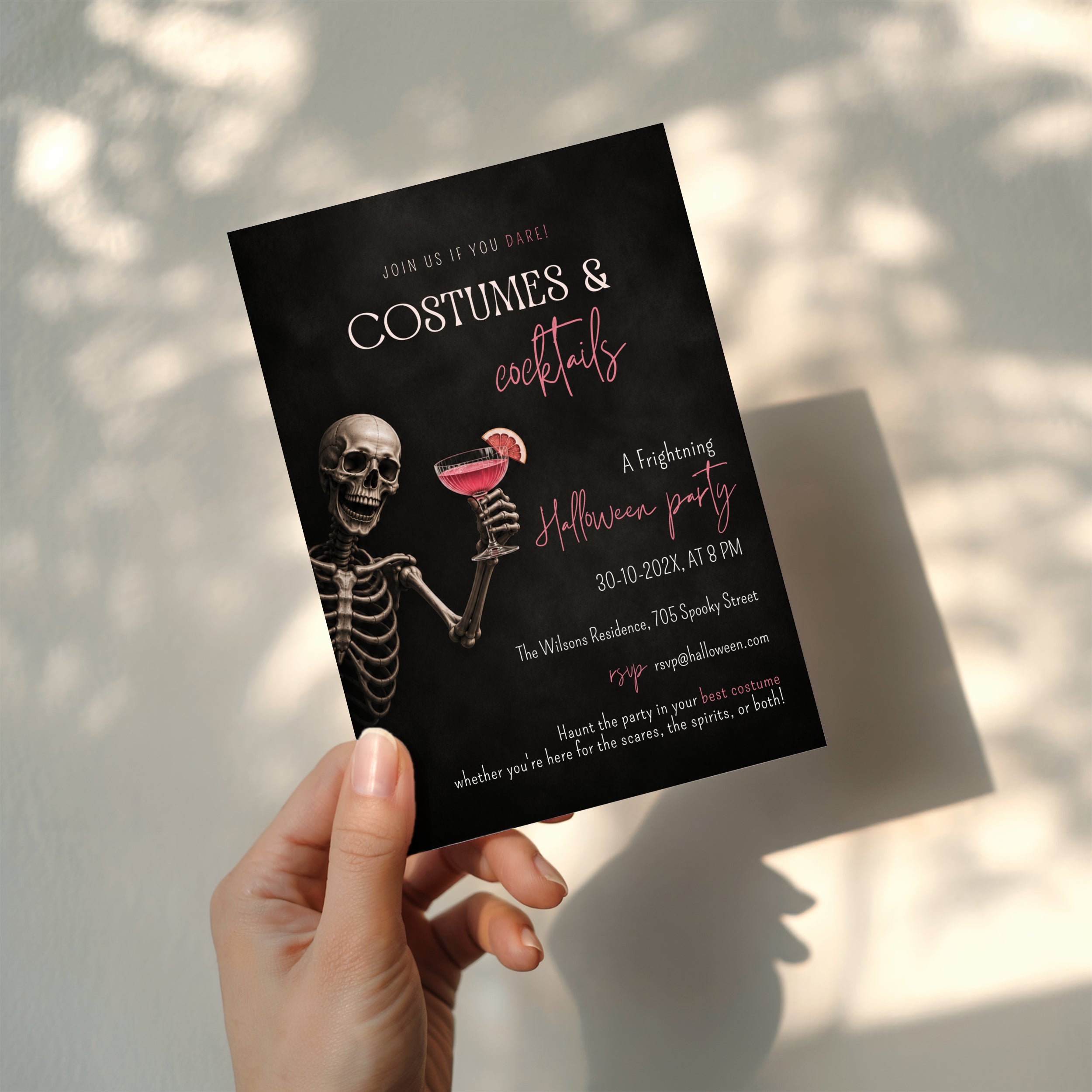 Costumes and Cocktails Halloween party invitation with a skeleton holding a pink cocktail, bold black background, and hot pink typography.