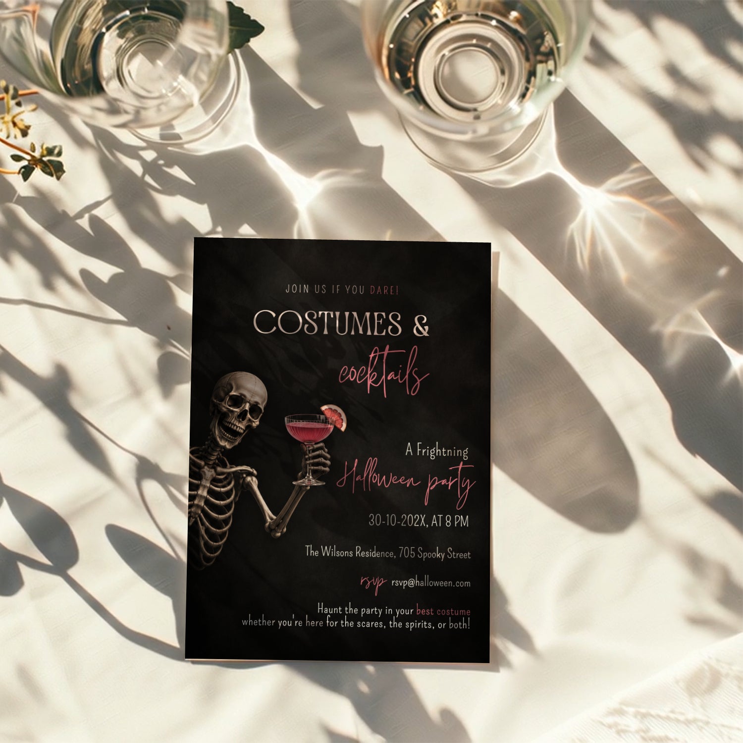 Costumes and Cocktails Halloween party invitation with a skeleton holding a pink cocktail, bold black background, and hot pink typography.
