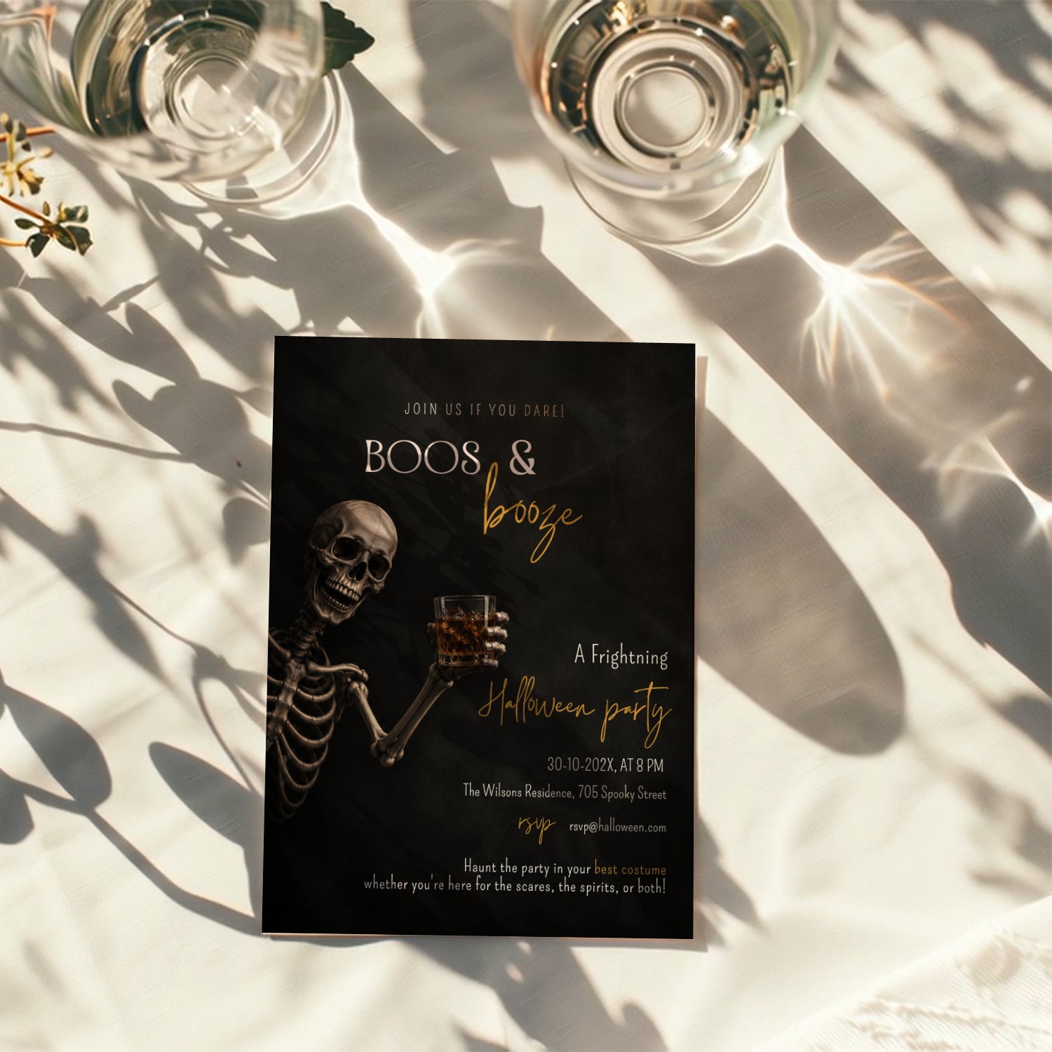 Boos and Booze Halloween party invitation featuring a skeleton holding a whiskey glass, black background, and amber typography for an adult Halloween party.