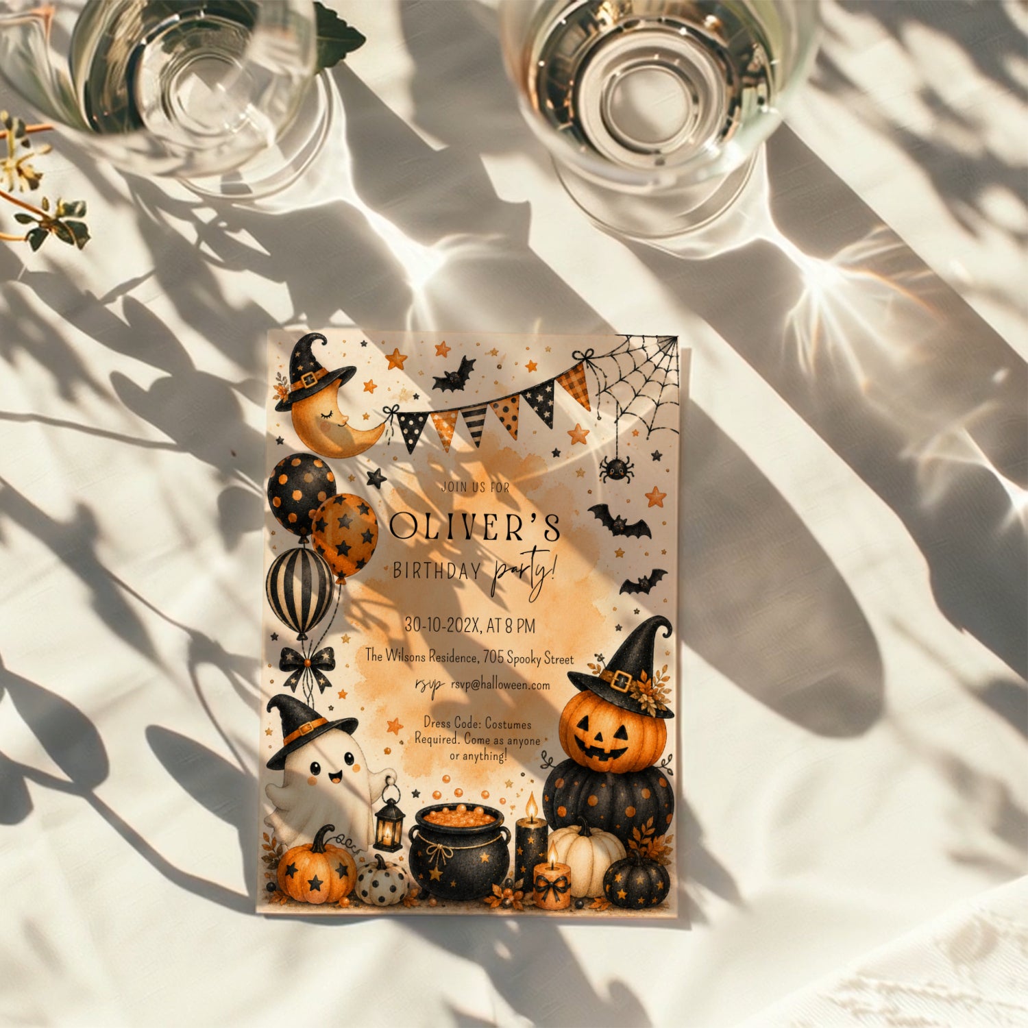 Watercolor Halloween birthday party invitation with a cute ghost, orange pumpkins, witch hats, bats, balloons, and a bubbling black cauldron.