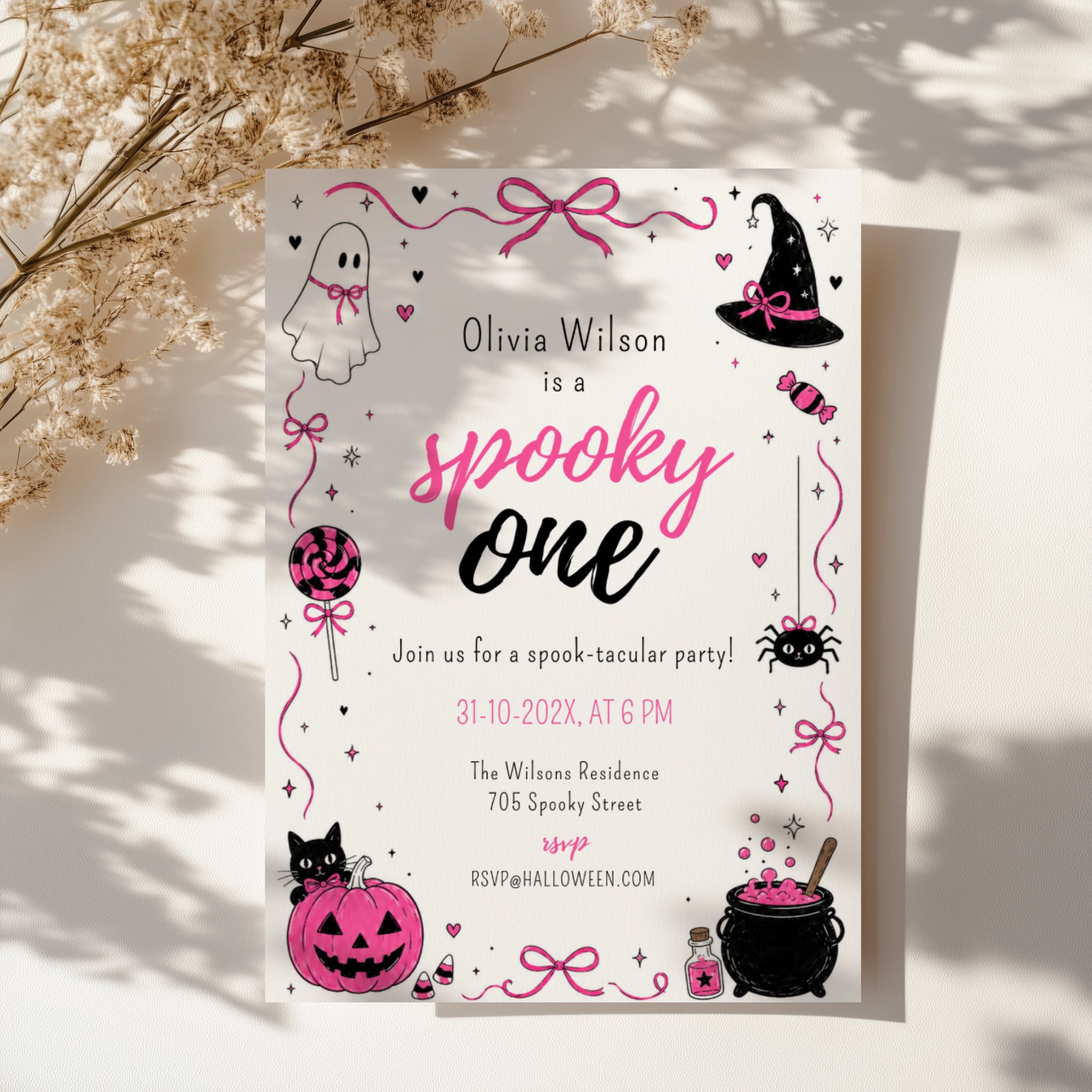Spooky One first birthday girl invitation in pink and black with cute ghost, witch hat, spider, lollipop, pink pumpkin and bubbling Halloween cauldron illustrations.