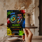 6 7 birthday invitation with colorful 67 numbers, bright graffiti paint splashes, neon colors, crown, stars and lightning details on a black background.