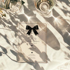 Elegant black bow birthday invitation with ivory background, pearl details and delicate vintage inspired lace accents.