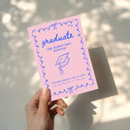 cute pink graduation invitation with blue hand drawn doodle border and playful typography